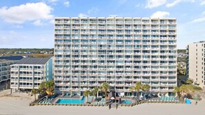 A multi-story hotel with numerous balconies and a pool area. - Garden City Beach Oceanfront Condo 912 | Rising Tides Properties Rental (Murrells Inlet)