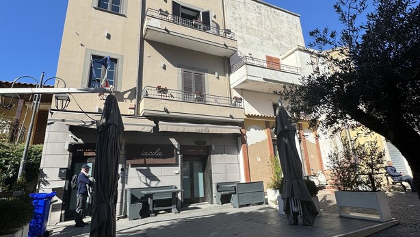 Un edificio con restaurante en la planta baja llamado "Iacola", que ofrece terraza y una entrada visible.