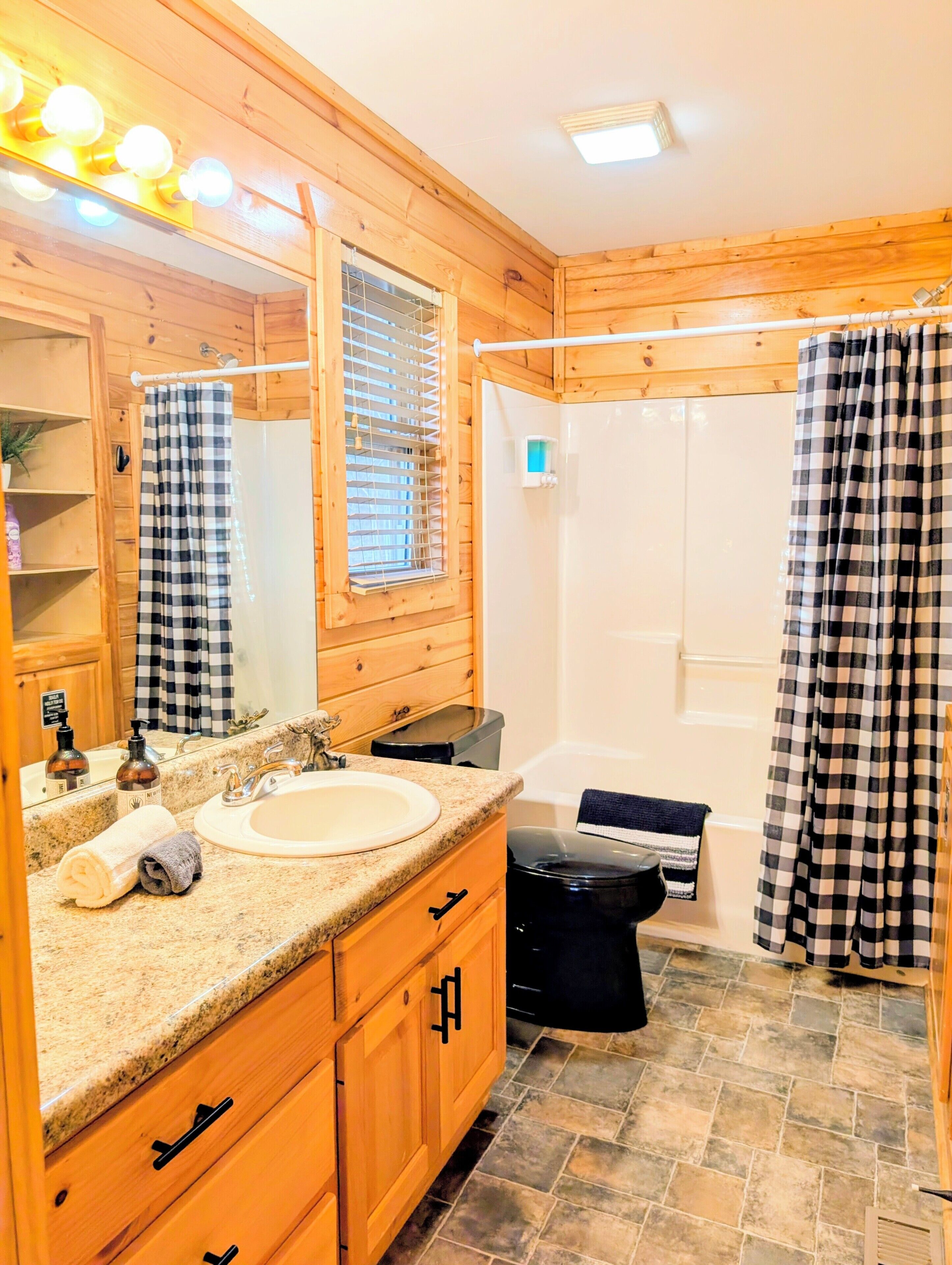 A wooden cabin bathroom with a sink, mirror, and shower.