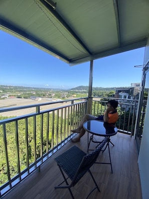 Enjoy the view from this balcony with a clear view of the surrounding area, featuring a table and chair.