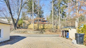 A paved driveway leading to a wooden deck with a house in the background. - Greenwood Lake Cottage w/ Shared Dock & Hot Tub! (West Milford)