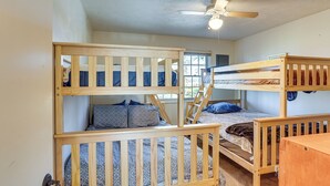 A bunk bed room with a ceiling fan, a window, and a wooden desk. - Boat Dock on Reelfoot Lake: Tiptonville Retreat (Tiptonville)