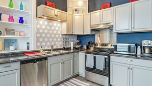 Una cocina moderna con electrodomésticos de acero inoxidable, armarios blancos y un salpicadero con diseño.