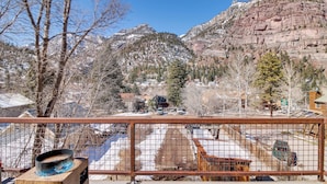 A mountain view with a fenced area, a wooden structure with a blue object, and a snowy landscape. - Cozy Ouray Hideaway: Mountain Views, Steps to Main (Ouray)