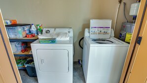 A laundry area with two washing machines, a water heater, and various cleaning supplies. - Cozy Ouray Hideaway: Mountain Views, Steps to Main (Ouray)