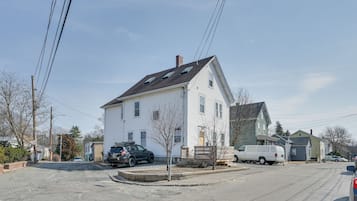 Situated on a corner lot, this charming house features a gabled roof and a chimney.