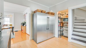 A modern kitchen with a stainless steel refrigerator, wooden flooring, and a built-in pantry. - Bright & Pet-friendly Home: 2 Mi to Harvard Square (Watertown)