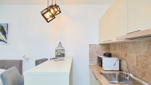 A modern kitchen with a central island, a built-in microwave, and a stainless steel sink. - Hedera Estate, Hedera Studio 3 (Dubrovnik)