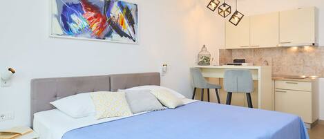 Un dormitorio moderno con una cama, un escritorio y una silla.