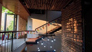 A wooden staircase with a metal railing, hanging light fixtures, and a wall with a wooden log pattern. - Ha Long May5  (Bai Chay)