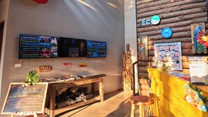 A cozy interior with a wooden ceiling, a rustic wall, and a seating area with stools. - Ha Long May5  (Bai Chay)