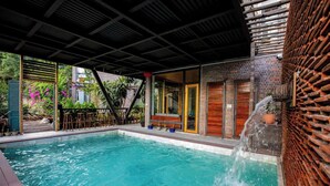 A swimming pool with a wooden deck and a brick wall. - Ha Long May5  (Bai Chay)
