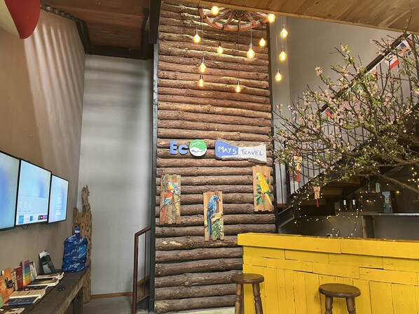 Un interior rústico con una pared de madera, una barra amarilla y un letrero que dice "MAY'S TRAVEL".