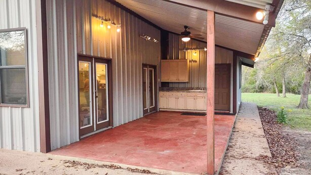 A modern building with a covered patio, a kitchen with wooden cabinets, and a glass door leading to a garage. - Oma's Haus in Franklin - Near Franklin Ranch Baseball Fields! (Franklin)