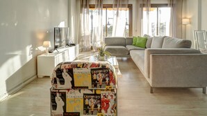 A modern living room with a sofa, a coffee table, and a TV. - Soleil by Hello Homes Sitges (Sitges)