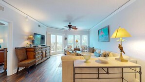 A spacious living room with a television, a dining table, and a sofa.