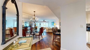 Un salon spacieux agrémenté d’un grand miroir, de meubles en bois et d’un lustre.