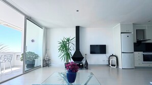 A modern kitchen with a built-in oven, a refrigerator, and a TV mounted on the wall. - Vistas Del Mar by Hello Homes Sitges (Sitges)