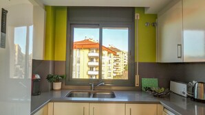 Una cocina moderna con un ventanal grande, un lavabo y un tostador.