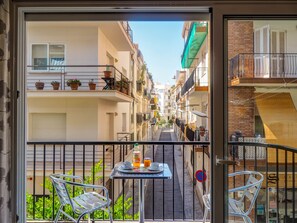 Ein Balkon mit Tisch, Stühlen und einer Wasserflasche.