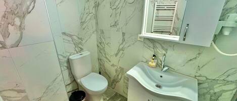 Ein Badezimmer mit Toilette, Waschbecken und Wänden aus Marmorplatten.