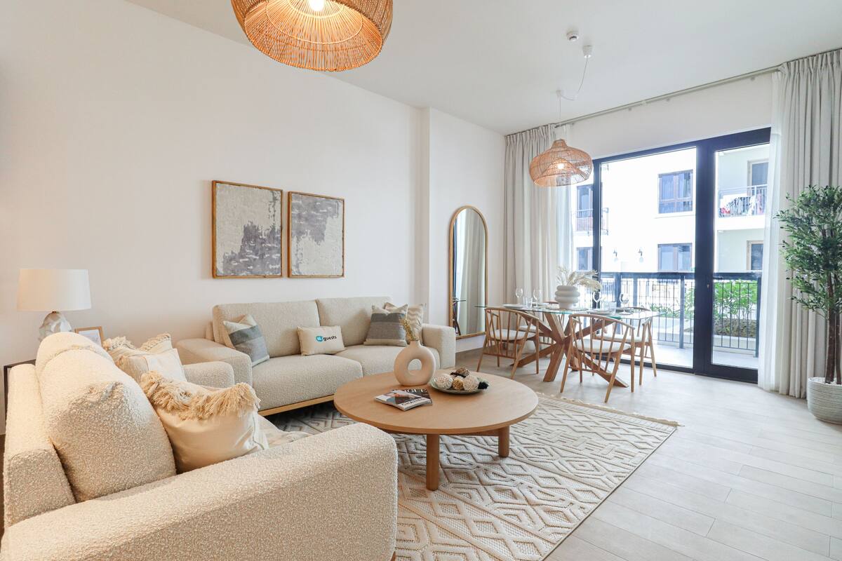 A spacious living room with a sofa set, a coffee table, and a dining area with a table and chairs.