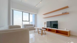 A modern living room with a large window, a flat-screen TV, and a minimalist design.