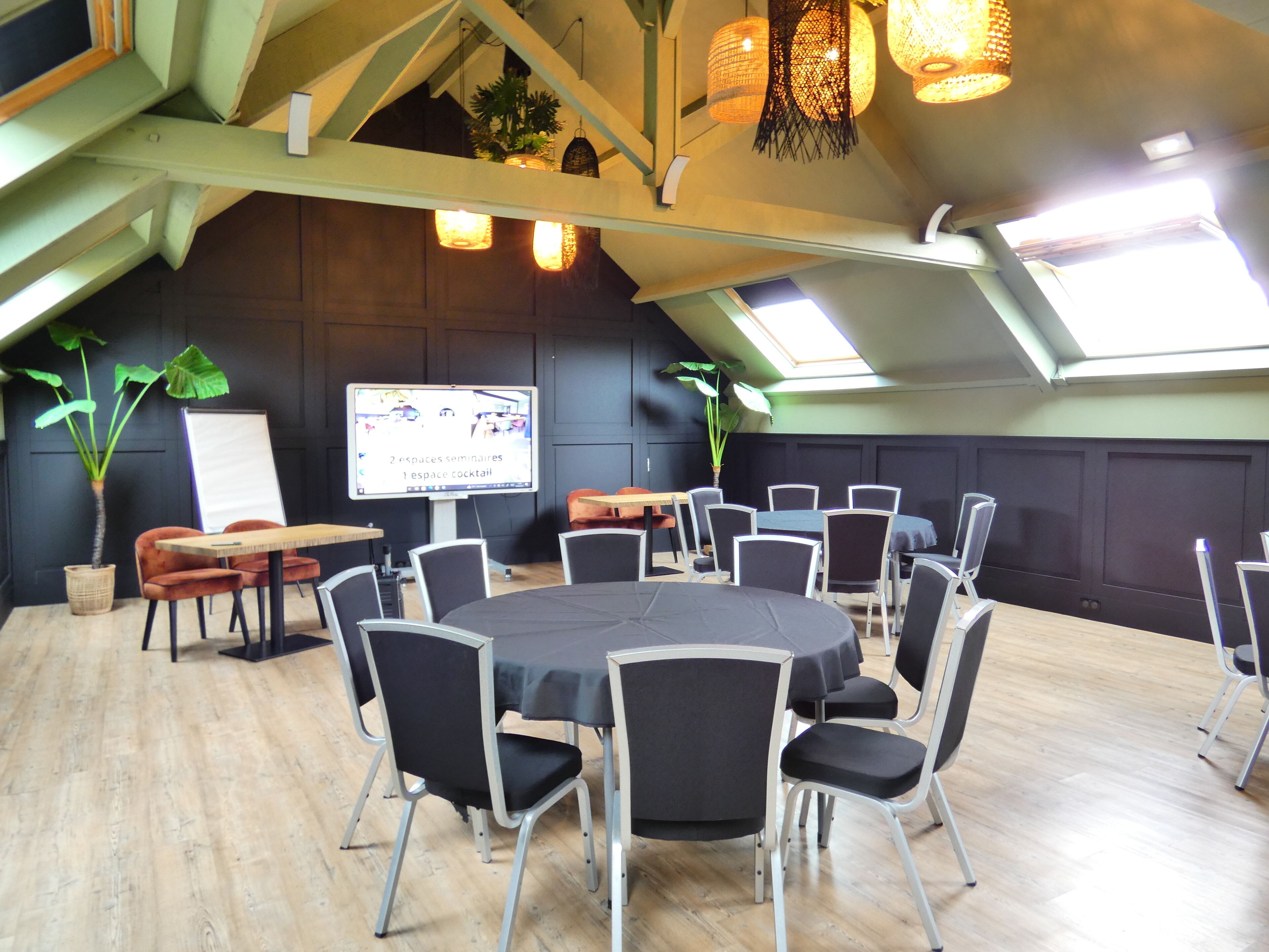 A conference room with a large table, multiple chairs, a whiteboard, and two potted plants.