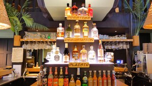 A bar area with a variety of liquor bottles and glasses. - Contact Hotel B&G (Limoges)