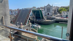 Een havenzicht met een brug, een kerk en een boot.