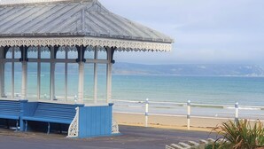 A gazebo with a view of the sea, benches, and a white fence along the beach. - Quay View Apartment - Four Bedroom Apartment, Sleeps 8 (Weymouth)