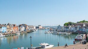 A harbor with boats docked along the waterfront, surrounded by colorful buildings. - Quay View Apartment - Four Bedroom Apartment, Sleeps 8 (Weymouth)