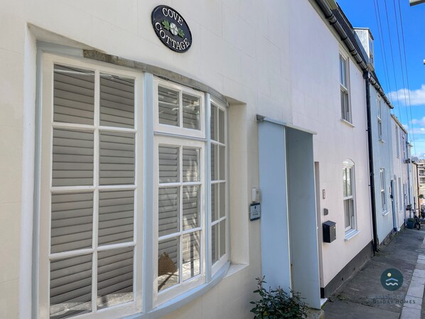 A white building with a sign reading "Cove Cottage." - Cove Cottage - Brewers Quay Harbour (Weymouth)