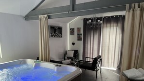 Une chambre dotée d’un jacuzzi, d’un coin repas et offrant une vue sur l’extérieur.