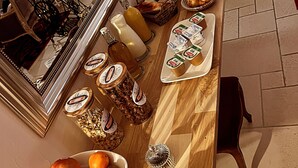 Une table à manger dressée avec divers plats et condiments, un miroir et une machine à coudre.