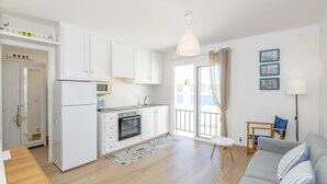 A modern apartment with a kitchen, dining area, and living room.