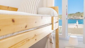 A bunk bed room with a view of the sea.