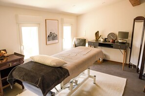 Ein Schlafzimmer mit Bett, Nachttisch, Sessel, Schreibtisch und Spiegel.