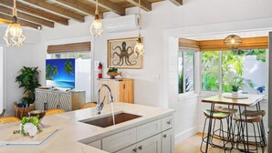 Una cucina moderna con un'isola grande, luci a sospensione e vista sull'esterno.