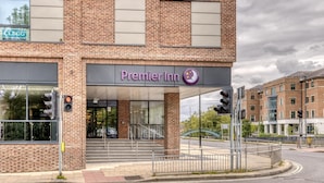 Een Premier Inn hotel met een gevel van baksteen, grote ramen en een zichtbare entree met treden.