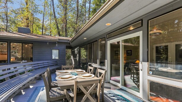 A covered patio with a table set for four, wooden chairs, and a bench. - Single Level Vacation Home w/ Private Pool (Hilton Head Island)
