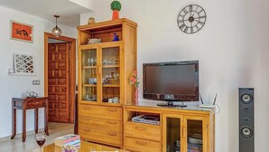 Ein Wohnzimmer mit Holzschrank, Fernseher und Lautsprechern.
