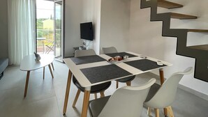Un comedor moderno con una mesa, sillas y una escalera.
