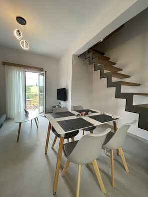 Uma sala de jantar moderna com uma mesa, cadeiras e uma escada.