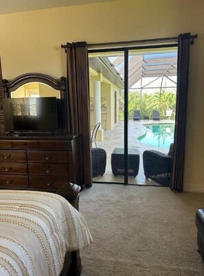 Relax in this serene hotel room with an outdoor area featuring a pool and lounge chairs.