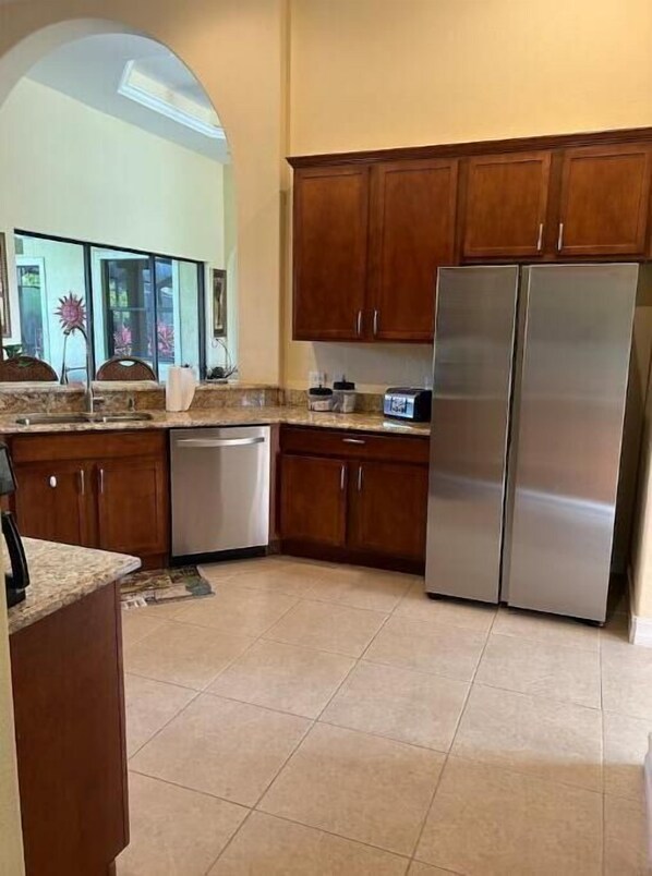 Kitchen area with a dishwasher, refrigerator, and countertop appliances.