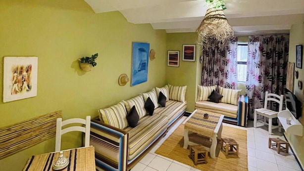 A living room with a sofa, a dining table, and chairs. - Beautiful Studio In Casablanca (Casablanca)