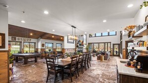 A spacious kitchen with a dining area, a pool table, and a bar.