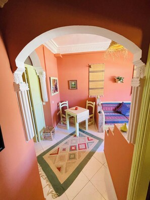 Ein gemütliches Wohnzimmer mit einer Couch, einem Esstisch und Stühlen.