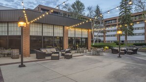 An outdoor patio area with wicker furniture and string lights. - King Studio Suite with Kitchenette in the heart of Racine! (Mount Pleasant)